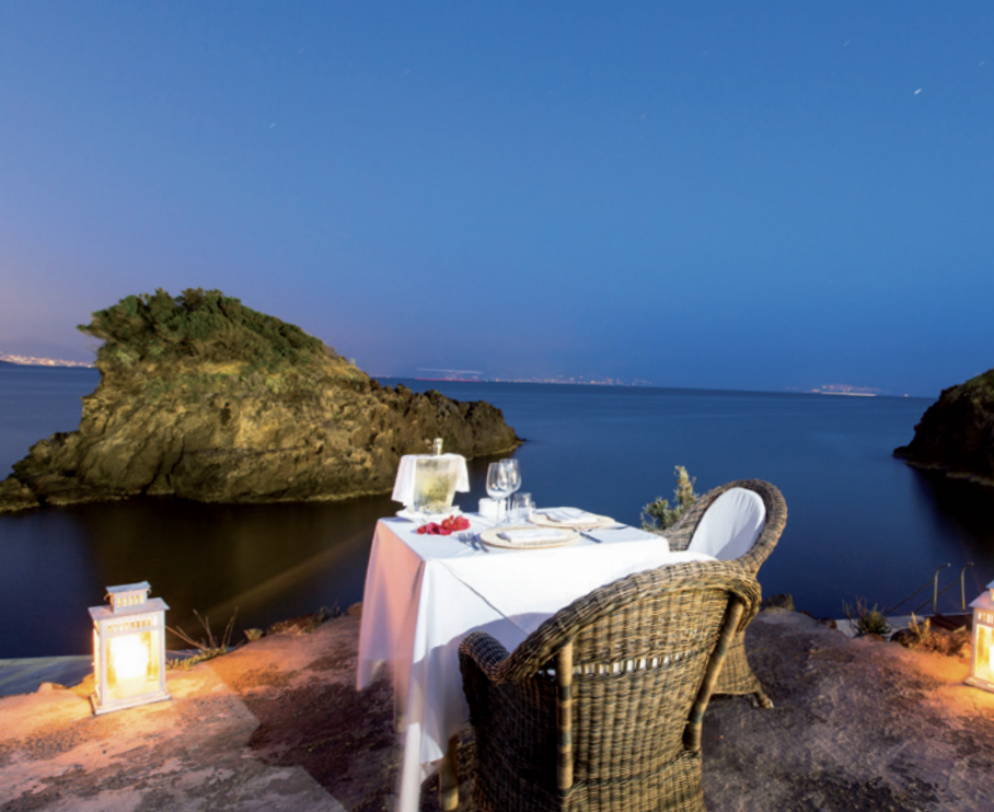 Eleganza sobria e coerente. Intorno, la baia di Cartaromana.